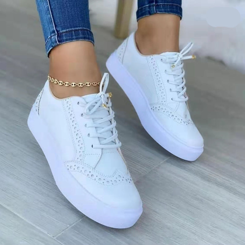 Weiße Damen-Sneaker mit runder Spitze, flachem Design und Schnürung, ideal für Casual-Outfits und Spaziergänge. Bequeme, modische Schuhe.