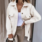 Damenmode: Elegante beige Jacke mit Knopfleiste und Taschen, kombiniert mit weißem Top und beigen Hosen. Perfekt für stilvolle Herbst-Looks.