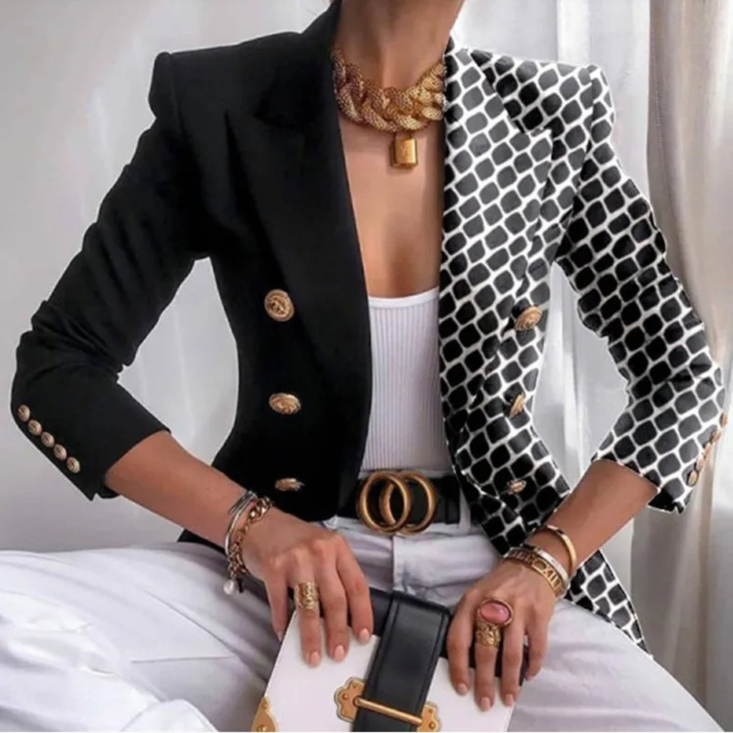 Eleganter Damenblazer mit schwarz-weißem Muster, goldenen Knöpfen und Accessoires. Perfekt für stilvolle Business- und Freizeitlooks.