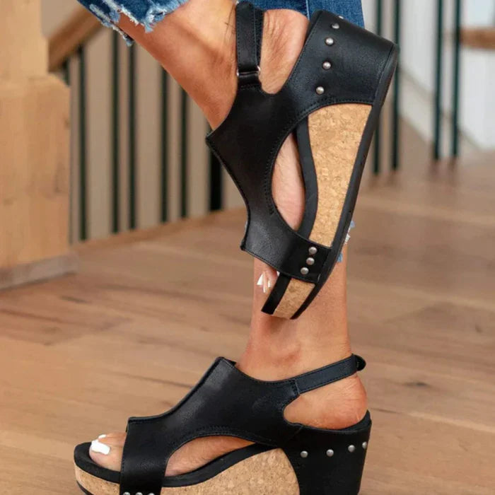 Schwarze Keilsandalen mit Korksohle und Nieten, ideal für Sommermode. Bequeme Damen-Schuhe, perfekt für lässige und stilvolle Outfits.