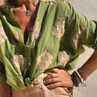 Grünes Hemd mit Stickerei, geknotet getragen. Perfekt für Sommermode, Boho-Stil, lässige Outfits. Ideal für Damenmode und Freizeitkleidung.