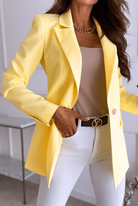 Eleganter gelber Blazer für Damen, kombiniert mit weißer Hose und beigem Top. Perfekt für stilvolle Business- und Freizeitlooks.