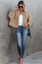 Frau in modischer Cordjacke, Jeans und Sandalen. Trendige Damenmode, lässiger Look, Streetstyle, Herbstoutfit, stilvolle Sonnenbrille.