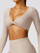 Damen Sport-BH in Beige, langärmlig, mit Twist-Design. Perfekt für Yoga und Fitness. Atmungsaktiv, elastisch, modisch.