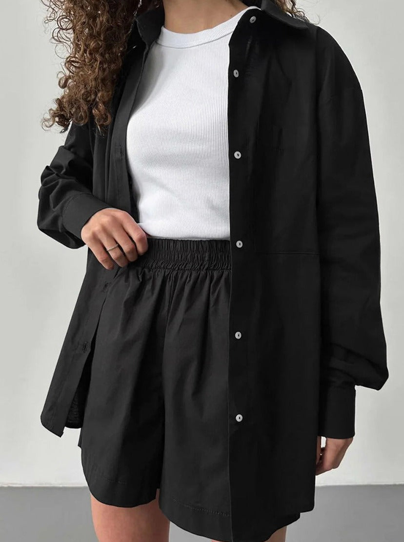 Schwarzes Oversize-Hemd und Shorts-Set für Damen, kombiniert mit weißem Tanktop. Modischer Freizeitlook, ideal für Sommer und Frühling.