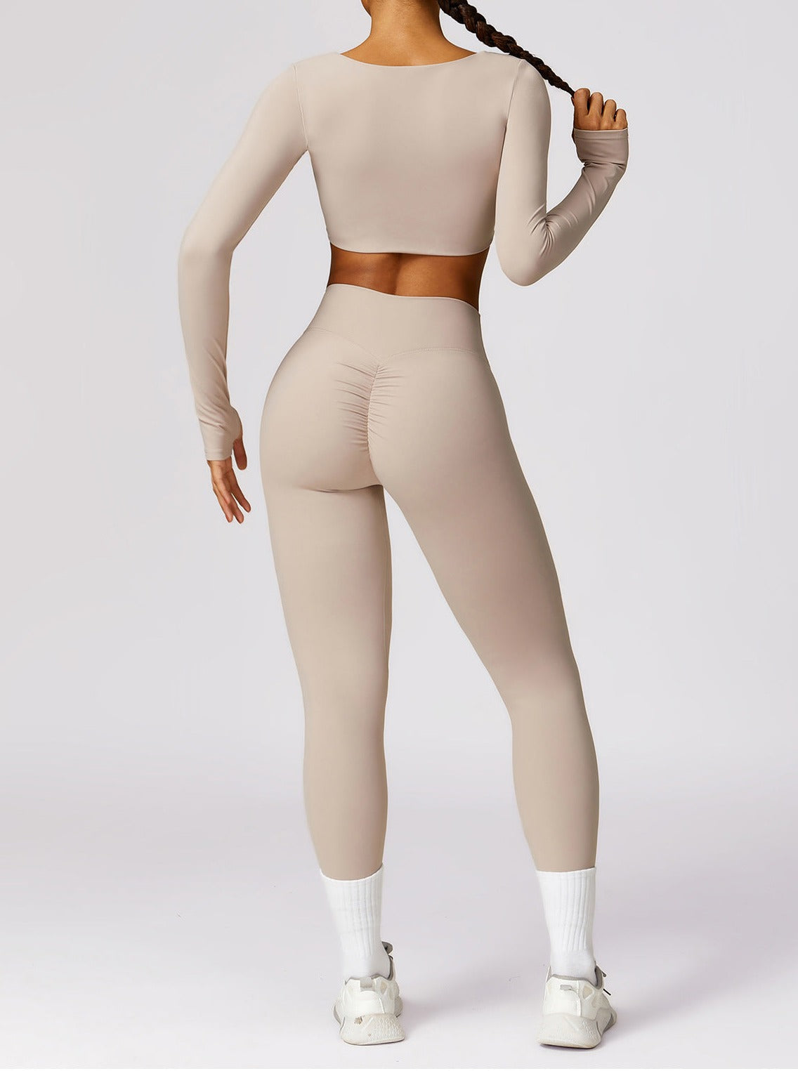 Damen-Sportbekleidung: Nahtloses, hautenges Set in Beige, bestehend aus Langarm-Top und Leggings. Ideal für Fitness und Yoga.