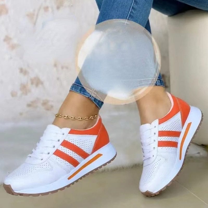 Weiße und orangefarbene Sneaker mit perforiertem Design, ideal für Damenmode. Bequeme Sportschuhe, perfekt für Freizeit und Sport.