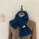 Eleganter blauer Wollschal auf braunem Mantel, ideal für Herbstmode. Hochwertige Accessoires, stilvoll und warm. Perfekt für kalte Tage.