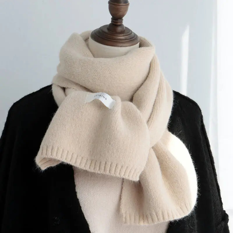 Beiger Kaschmirschal auf schwarzem Mantel, elegant und weich, ideal für Herbst und Winter. Luxuriöses Accessoire, modisch und warm.