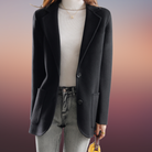 Eleganter schwarzer Blazer für Damen, kombiniert mit weißem Rollkragenpullover und grauer Jeans. Perfekt für Business und Freizeitmode.