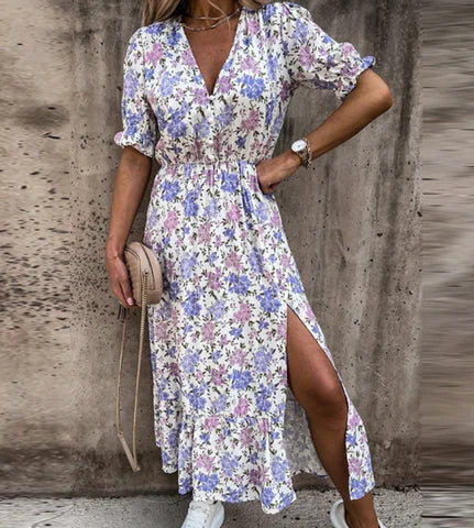 Feminines Sommerkleid mit floralem Muster, V-Ausschnitt und Seitenschlitz. Perfekt für Freizeitmode, ideal für warme Tage und stilvolle Outfits.