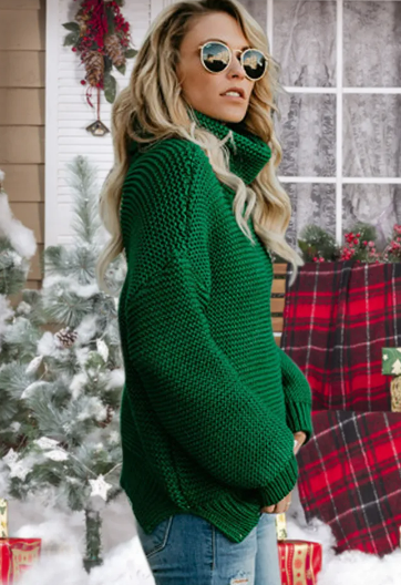 Frau im grünen Strickpullover vor weihnachtlicher Kulisse mit Tannenbaum und Geschenken. Wintermode, Strickmode, festliche Kleidung.