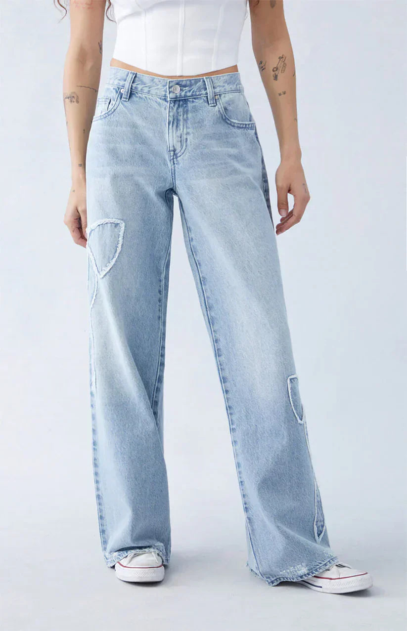 Damen-Jeans mit weitem Bein, hellblauem Denim und Herz-Patches. Modische, lässige Passform, ideal für trendige Streetwear-Looks.