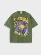 Dunkelgrünes T-Shirt mit Sonnen- und Mondmotiv, Schmetterling und Blumen. Text: "Sunshine Stay Magical". Perfekt für lässige, trendige Outfits.