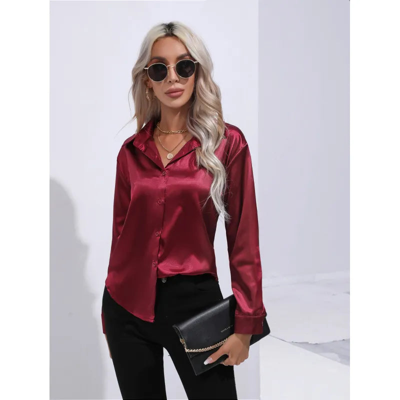 Damenmode: Elegante, rote Satinbluse mit langen Ärmeln, kombiniert mit schwarzer Hose. Perfekt für stilvolle, moderne Outfits.