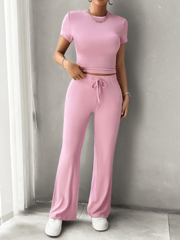 Damen Zweiteiler Set in Rosa, bestehend aus Crop-Top und Schlaghose. Perfekt für Freizeit und Sport. Bequemes, modisches Outfit für Frauen.